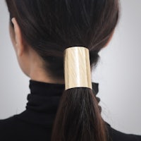 the back view of a woman wearing a gold hair clip