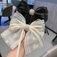 a person holding a black and white bow