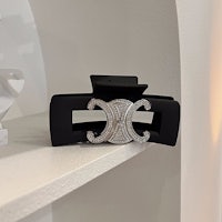 a black belt with a diamond buckle on top of a shelf