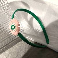 a green headband with a flower on it