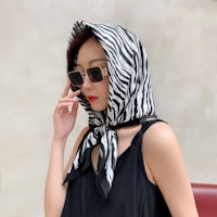 a woman wearing sunglasses and a zebra scarf