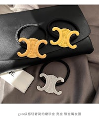 three gold and black hair ties on a black bag